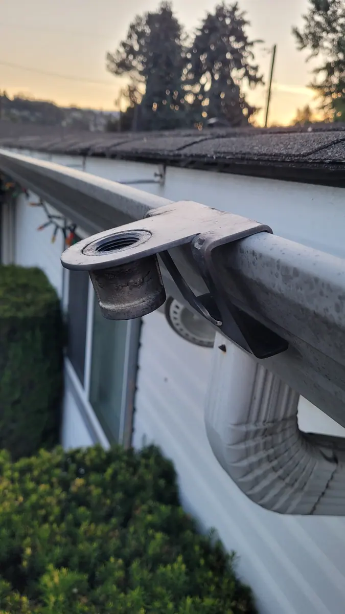Gutter mount sprinkler bracket hooked onto an eavestrough