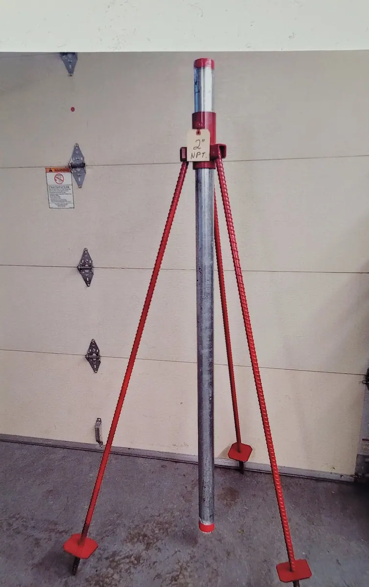 Tripod riser stand with flat feet, standing against the shop door